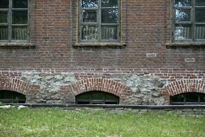 Basement windows of an old house and a green lawn. The basement of an old house. photo