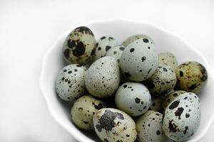 Quail eggs in a white plate. Food eggs on a white background. photo