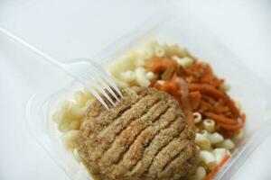 Delicious breakfast in a container. Breakfast with vermicelli fried cutlet and vegetables. photo