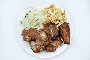 Beautiful fried pieces of pork meat. Pork kebab with vegetables. Meat on a plate. photo