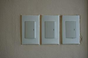 Household light switch on the wall. White plastic switch. photo