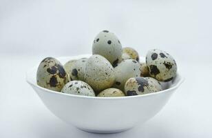 Quail eggs in a white plate. Food eggs on a white background. photo