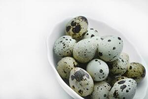 Quail eggs in a white plate. Food eggs on a white background. photo