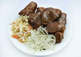 Beautiful fried pieces of pork meat. Pork kebab with vegetables. Meat on a plate. photo