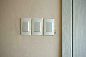 Household light switch on the wall. White plastic switch. photo