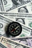 Compass and banknotes. US dollars. Navigation in the financial world. photo