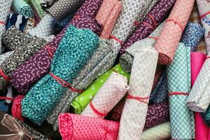 Detailed close up view on samples of cloth and fabrics in different colors found at a fabrics market photo