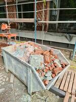 A container with rubble in front of a construction site. photo