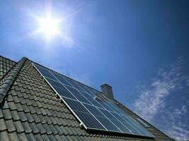 Solar panels producing clean energy on a roof of a residential house photo