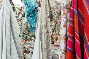 Detailed close up view on samples of cloth and fabrics in different colors found at a fabrics market photo