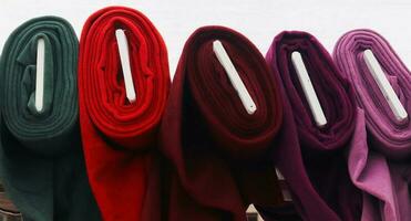 Detailed close up view on samples of cloth and fabrics in different colors found at a fabrics market photo