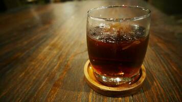 Transparent Glasses with sweet drinks inside with coke drink, with shadow and table background with ice cubes on a bar restaurant photo