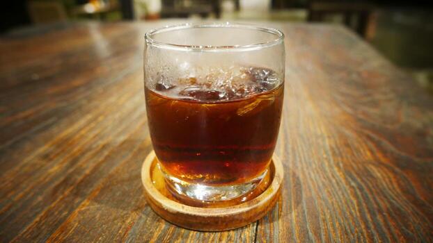 Transparent Glasses with sweet drinks inside with coke drink, with shadow and table background with ice cubes on a bar restaurant photo