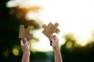 Jigsaw in hand, a puzzle piece that is critical to success. Creativity, ideas, initiative, unity, teamwork photo