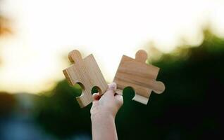 Jigsaw in hand, a puzzle piece that is critical to success. Creativity, ideas, initiative, unity, teamwork photo