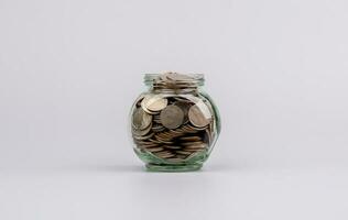 Saving coins in a glass jar saving money to build the future Saving money for business. Income. Salary. Savings concept. photo