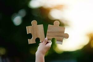 Jigsaw in hand, a puzzle piece that is critical to success. Creativity, ideas, initiative, unity, teamwork photo