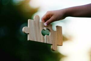 Jigsaw in hand, a puzzle piece that is critical to success. Creativity, ideas, initiative, unity, teamwork photo