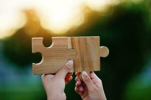 Jigsaw in hand, a puzzle piece that is critical to success. Creativity, ideas, initiative, unity, teamwork photo