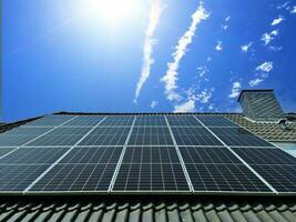 Solar panels producing clean energy on a roof of a residential house photo