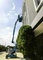 grúa manlift con elevación de plataforma hasta la azotea de un edificio foto