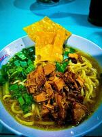 Mie ayam is a food from Indonesia which is made from noodles mixed with chicken photo