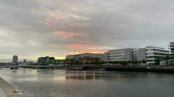 High-rise buildings by the river. Beautiful sunset in Dublin. photo