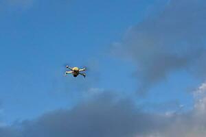 Small Drone Flying Above Blue Sky photo