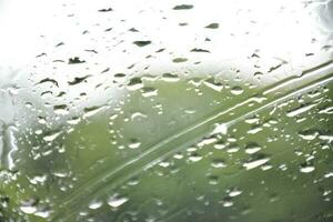 Blurred image of raindrops on the rear view mirror of car, soft focus photo