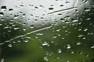 Blurred image of raindrops on the rear view mirror of car, soft focus photo