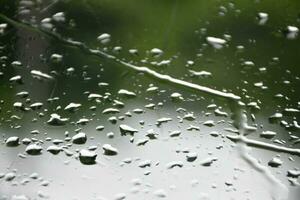 Blurred image of raindrops on the rear view mirror of car, soft focus photo