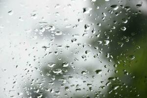 borroso imagen de gotas de lluvia en el posterior ver espejo de auto, suave atención foto