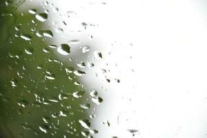 borroso imagen de gotas de lluvia en el posterior ver espejo de auto, suave atención foto