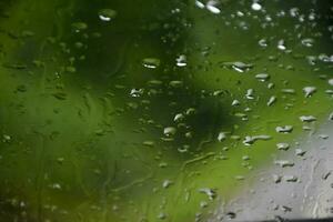 Blurred image of raindrops on the rear view mirror of car, soft focus photo