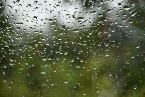 Blurred image of raindrops on the rear view mirror of car, soft focus photo