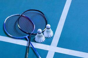 volante de bádminton blanco crema y raqueta en el suelo en la cancha de bádminton interior, espacio para copiar, enfoque suave y selectivo en los volantes. foto