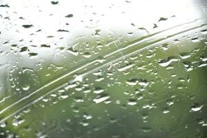 Blurred image of raindrops on the rear view mirror of car, soft focus photo