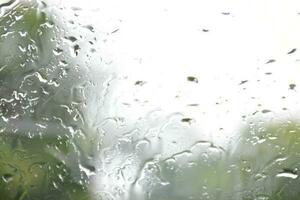 Blurred image of raindrops on the rear view mirror of car, soft focus photo