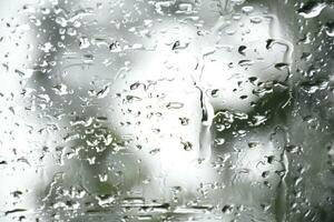 Blurred image of raindrops on the rear view mirror of car, soft focus photo