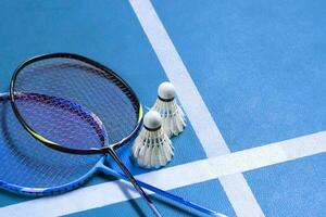 Badminton equipments, rackets and white cream shuttlecocks, on sand floor of outdoor badminton court, selective focus, concept for outdoor activity and outdoor sports for health. photo