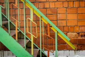 old iron staircase of a red brick wall photo