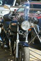 motorcycle standing on street against backdrop Parking. photo