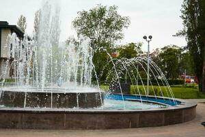 Photo of working fountain in park during day.