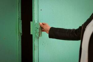 The girl opens the green metal door Entrance. photo