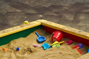 plastic children toys in sandbox at playground. photo