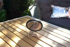 round makeup mirror stands on a turnip table. photo