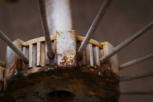 Old rusty metal spokes wheel. Bicycle construction photo