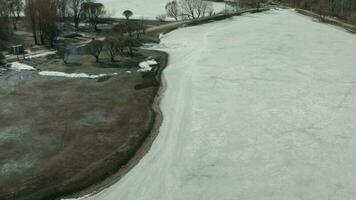 Bird's eye view on frozen lake in city park. video