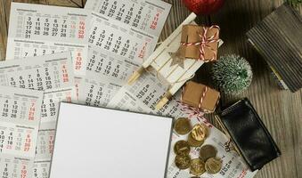 Blank sheet of paper and small purse with coins on the New Year's background. photo