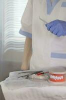 estéril algodón servilletas, mandíbula modelo y estomatológico herramientas en un mesa. foto